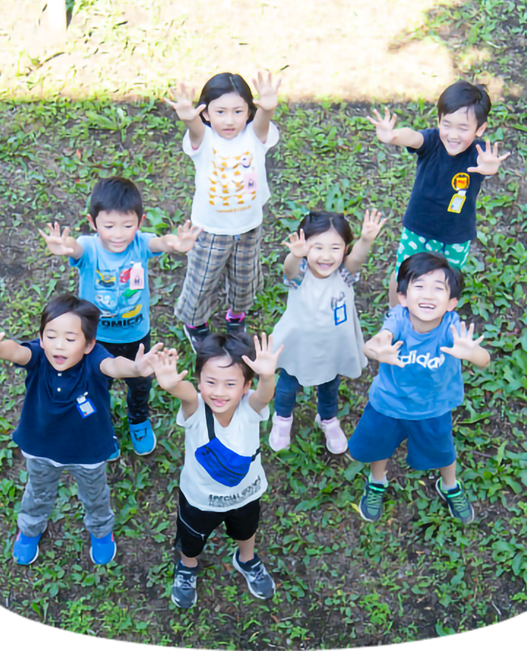 外で笑顔で手を挙げる子どもたち７名